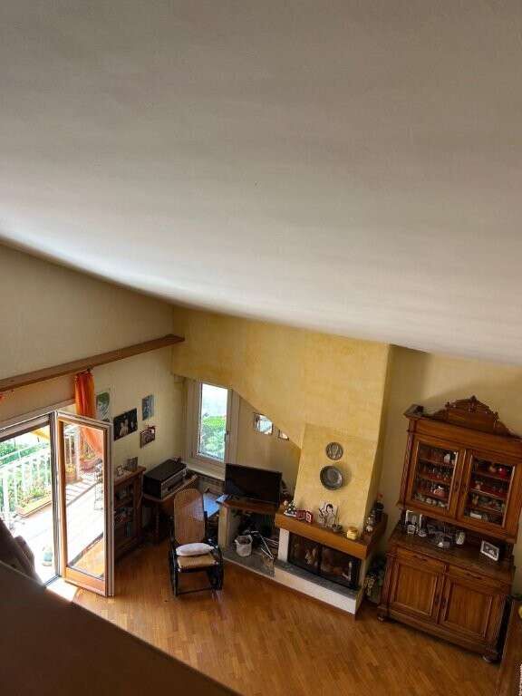 Spacious living room with balcony access in a luxurious Ariccia penthouse apartment.