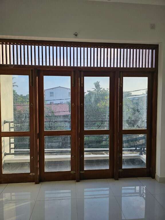 Spacious condo with large wooden framed glass doors opening to balcony views. Modern interior perfec.