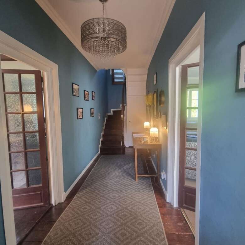 Walled hallway with a chandelier, staircase, and classic decor in a stunning stone mansion.