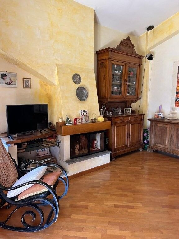 Elegant living room with vintage furniture and warm yellow walls in Ariccia penthouse apartment.