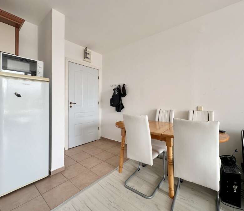 Interior view of a 1-bedroom apartment in Nessebar Fort Club, Sunny Beach, with dining area and basi.