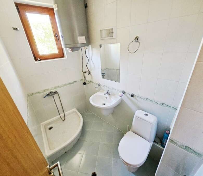 Bathroom with shower, toilet, and sink in Vineyards SPA Resort apartment.