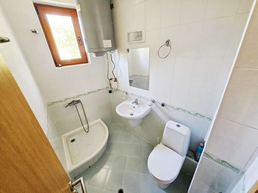 Bathroom with shower, toilet, and sink in Vineyards SPA Resort apartment.