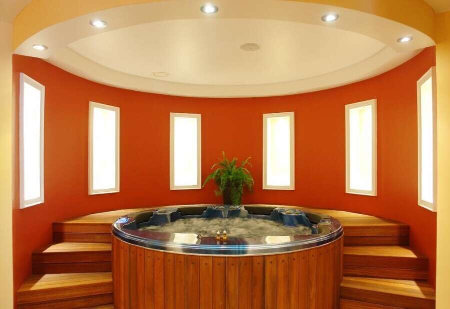 Indoor Jacuzzi with multiple windows and warm lighting.