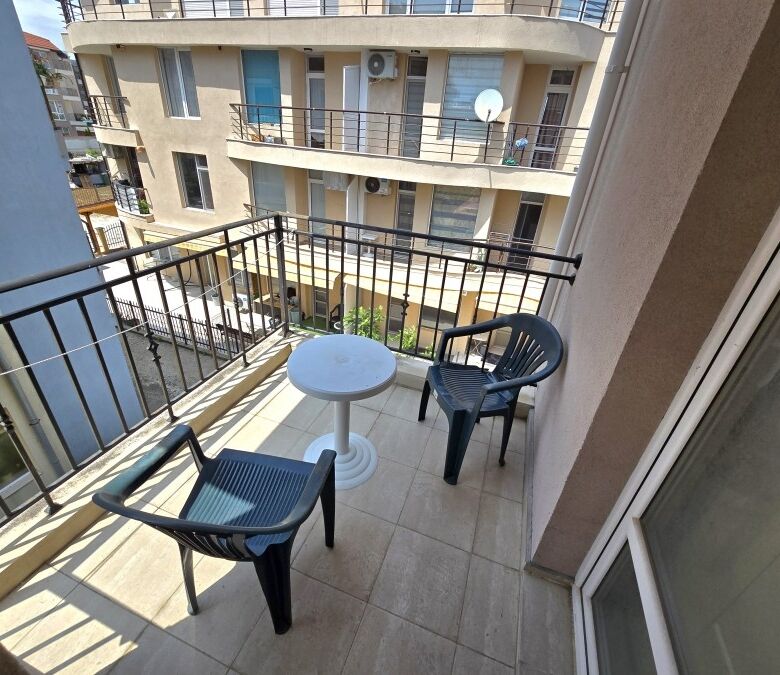 Small balcony with seating in a central Ravda apartment, no maintenance fee.