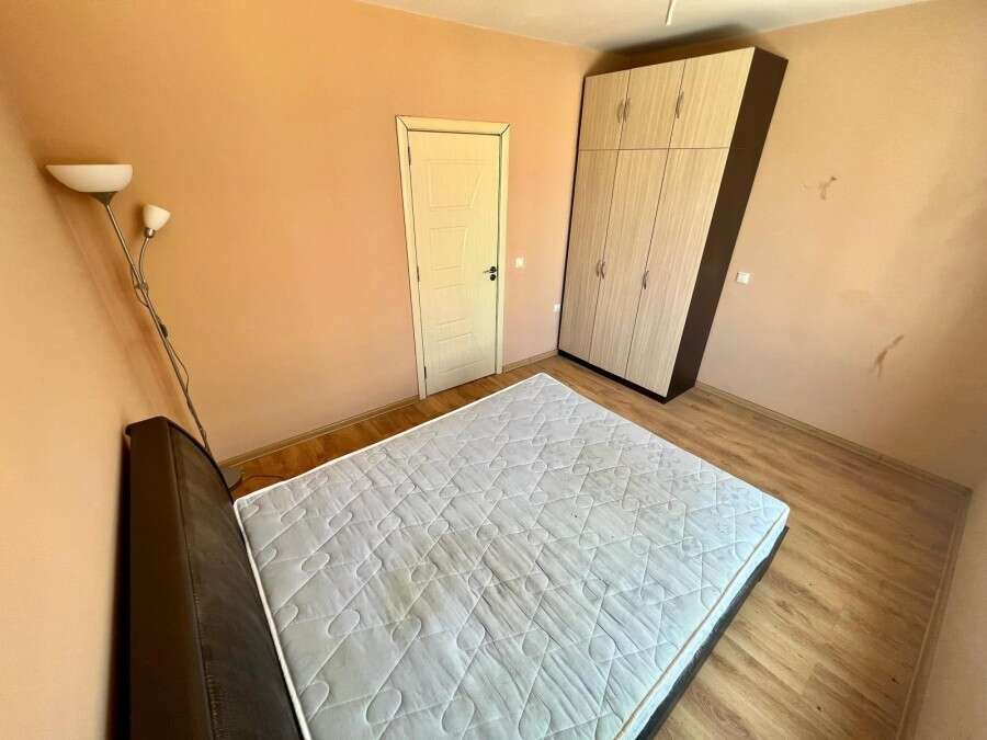 Interior view of a 1-bedroom apartment in Ravda, featuring a bed, wardrobe, and simple decor.