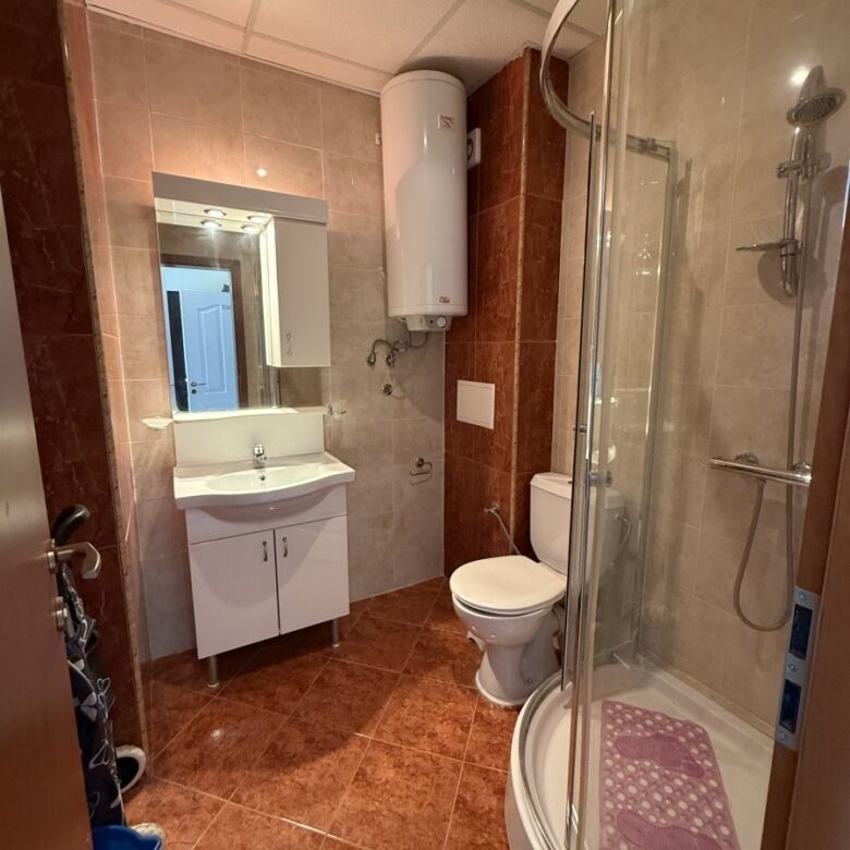 Bathroom with shower, toilet, and sink in a compact Sunny Beach studio.