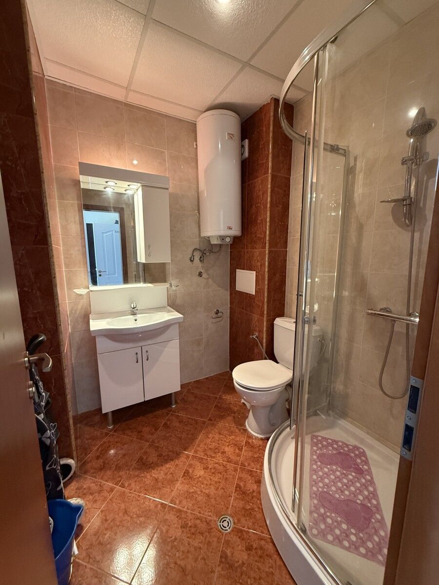Bathroom with shower, toilet, and sink in a compact Sunny Beach studio.