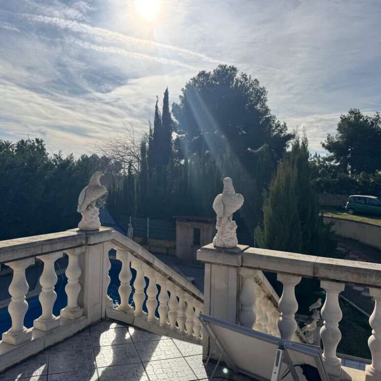 Elegant villa terrace overlooking lush garden and trees in Tarragona.