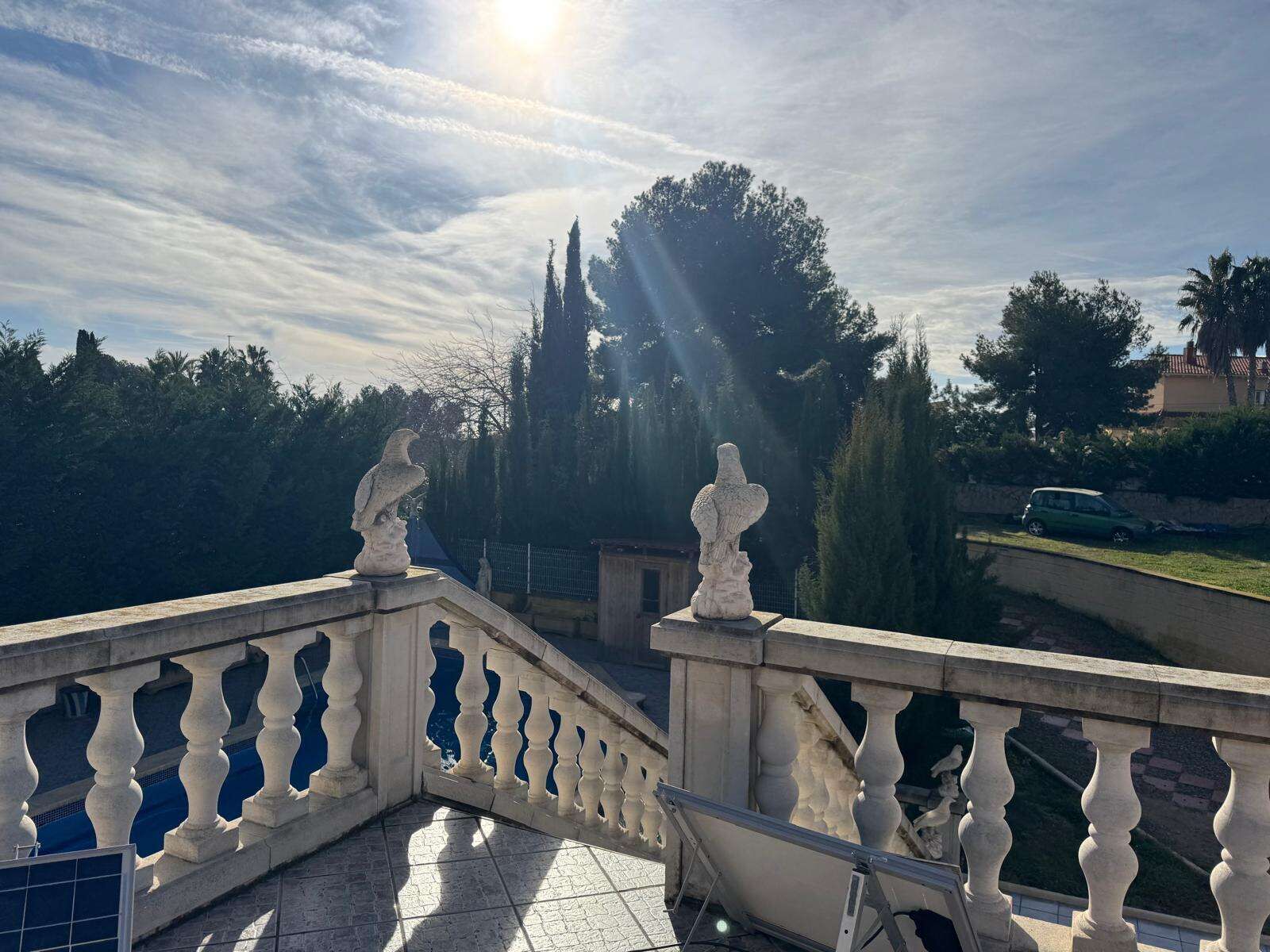 Elegant villa terrace overlooking lush garden and trees in Tarragona.