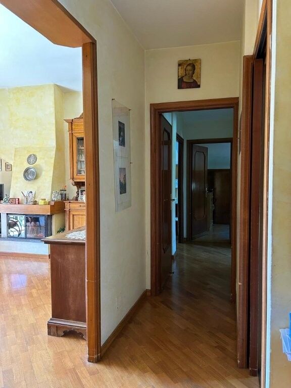 Spacious hallway leading to a luxurious penthouse apartment in Ariccia, Rome, featuring classic deco.