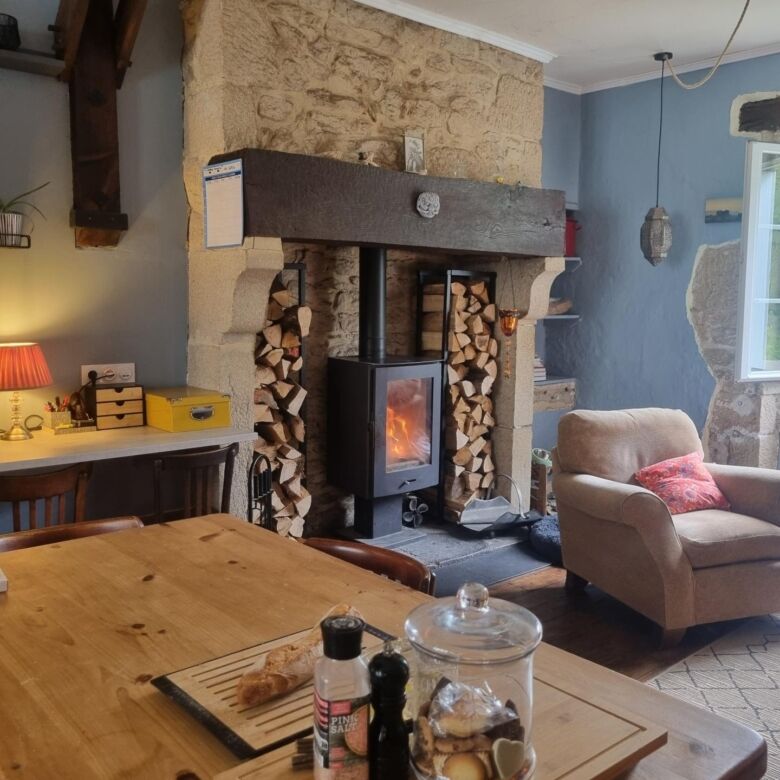 Cozy living room featuring a rustic stone fireplace and comfortable seating in a stunning Bugeat man.