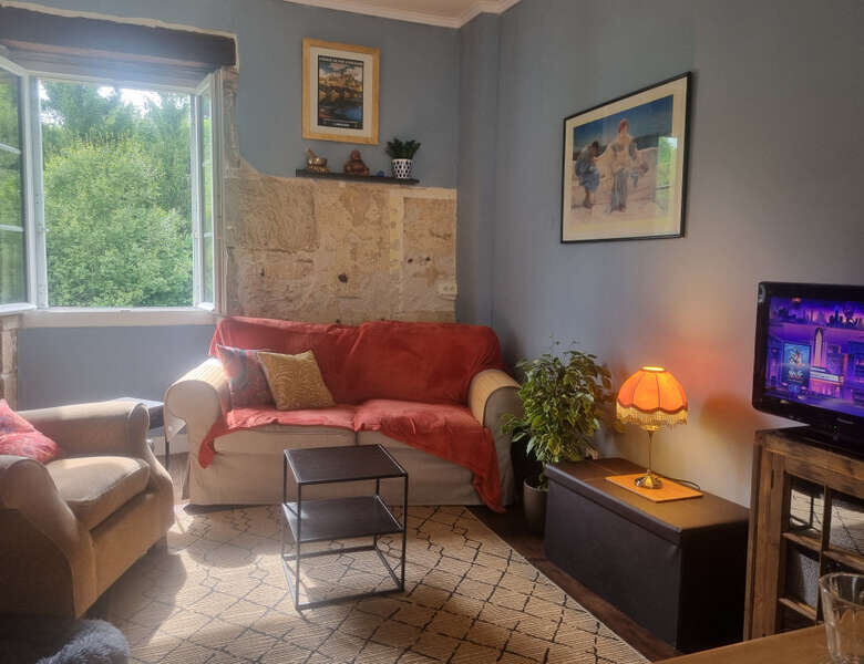 Interior view of a cozy living room in a stone mansion with comfortable sofas and natural light.