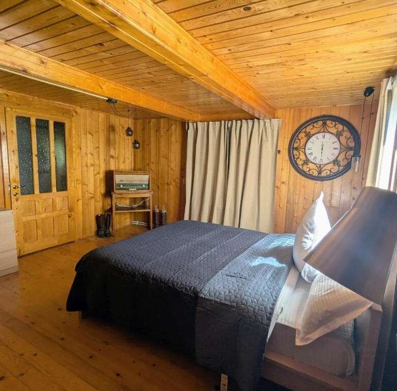 Chiriteni property featuring a warm, rustic bedroom with wooden walls and ceiling. Perfect for comfo.