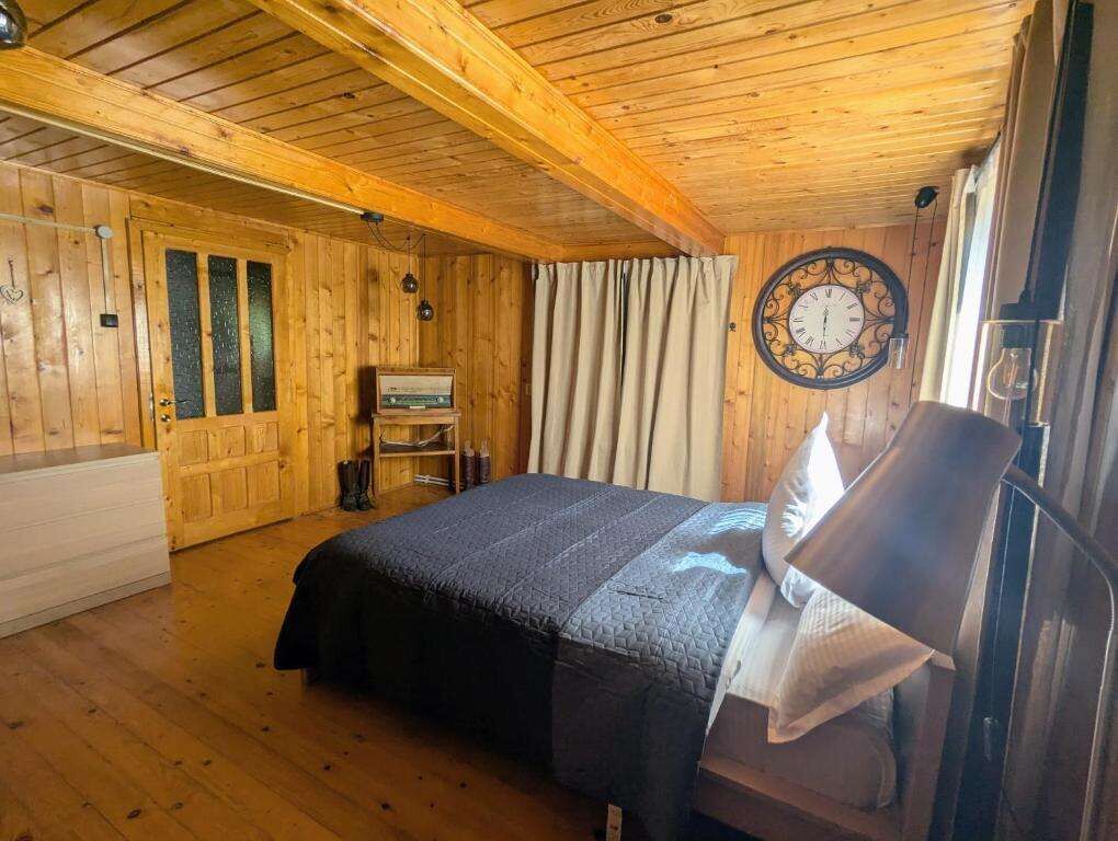 Chiriteni property featuring a warm, rustic bedroom with wooden walls and ceiling. Perfect for comfo.