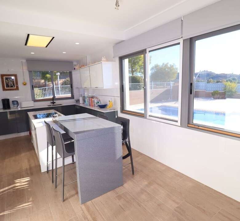 Elegant kitchen with modern appliances and large windows overlooking the pool.