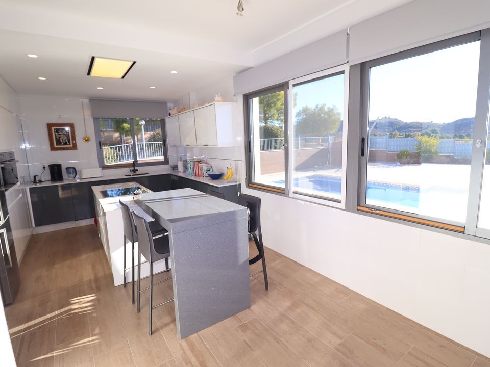 Elegant kitchen with modern appliances and large windows overlooking the pool.