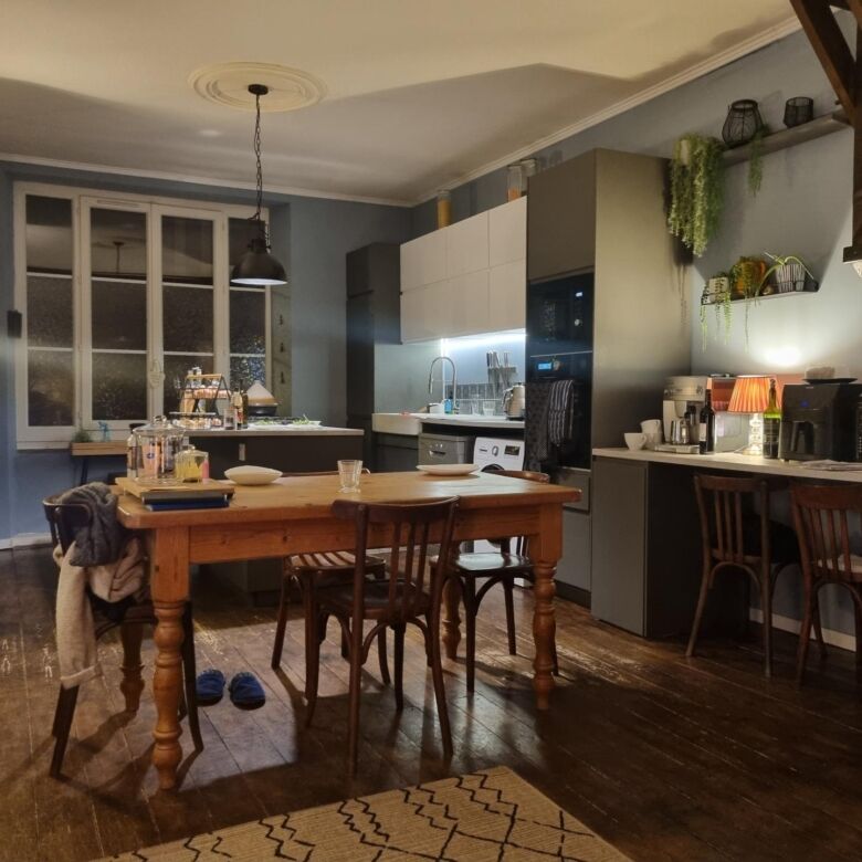 Elegant interior of a stone mansion featuring a modern kitchen and cozy dining space in Bugeat.