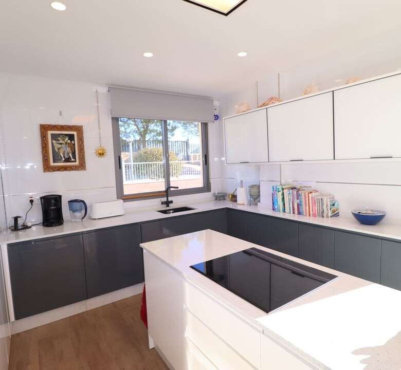 Spacious modern kitchen with sleek cabinets and a large window in a luxury villa in Aledo Murcia.