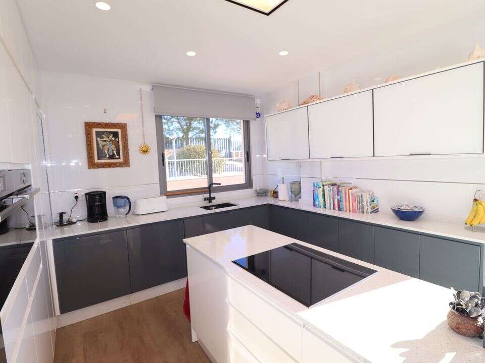 Spacious modern kitchen with sleek cabinets and a large window in a luxury villa in Aledo Murcia.