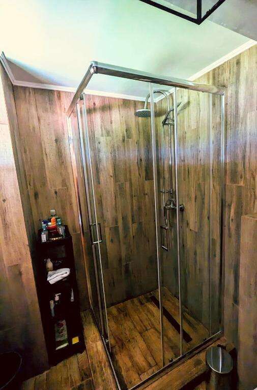 Elegant wooden interior shower stall with glass doors.