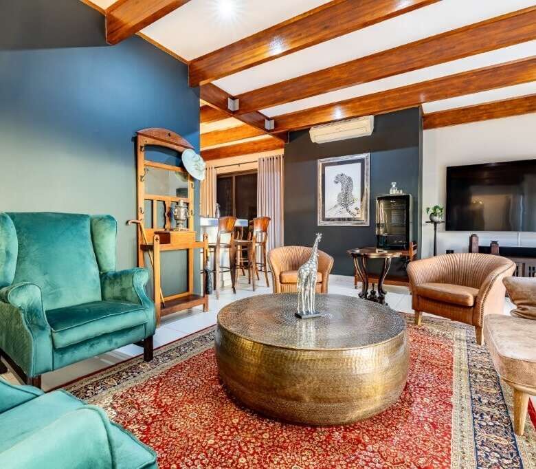 Elegant living room with stylish furniture and wooden ceiling beams in a luxury estate in Hluhluwe.