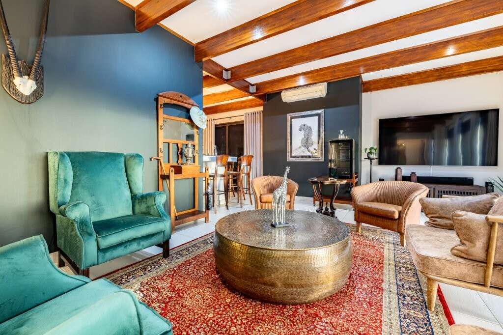 Elegant living room with stylish furniture and wooden ceiling beams in a luxury estate in Hluhluwe.