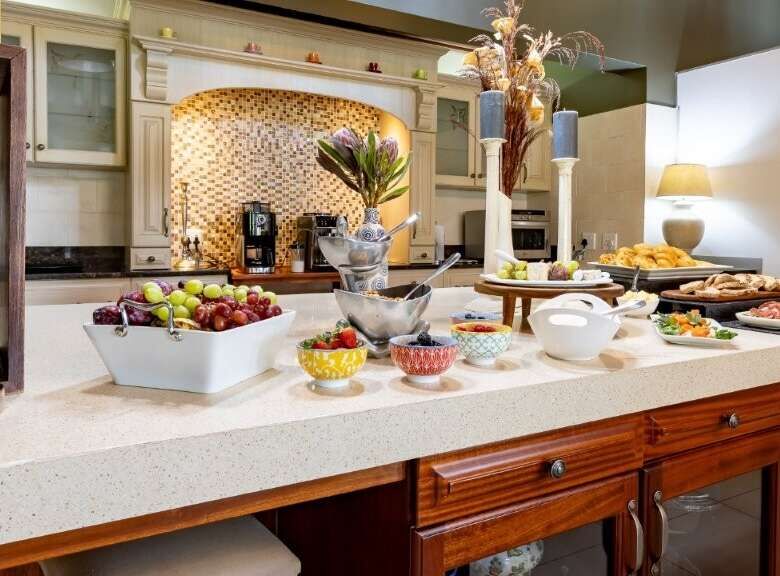 Elegant kitchen with modern appliances and fresh fruit display in a luxury estate.