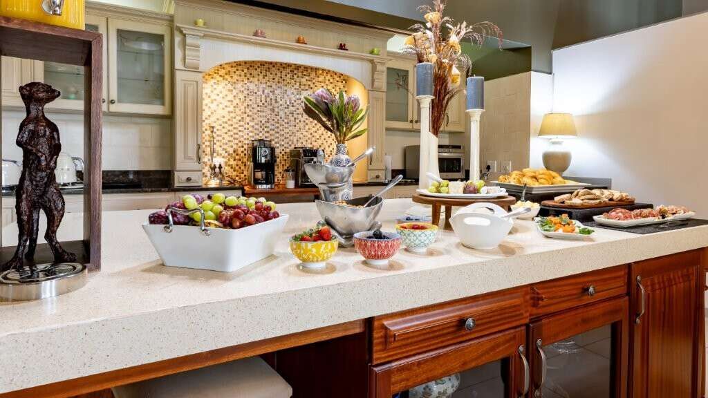Elegant kitchen with modern appliances and fresh fruit display in a luxury estate.