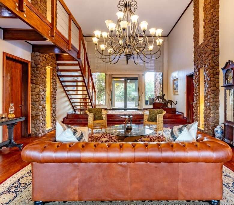 Elegant living room with high ceilings and rustic stone accents in Kwa-Zulu Natal.