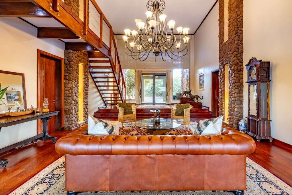 Elegant living room with high ceilings and rustic stone accents in Kwa-Zulu Natal.