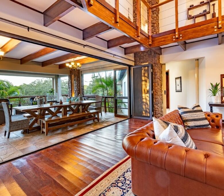 Elegant living room with large glass doors opening to lush outdoor scenery in Hluhluwe Kwa-Zulu Nata.