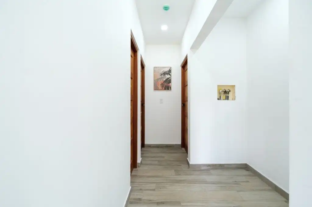 Modern condo hallway with white walls and wooden door frames in Pedasi.