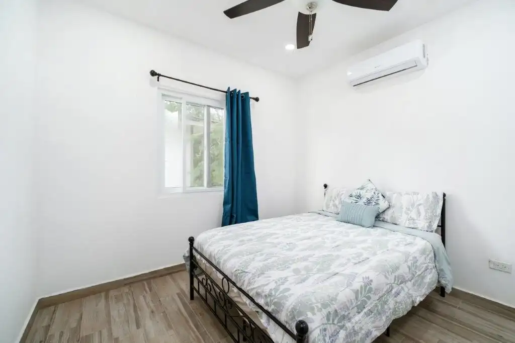 Condo bedroom with ocean view, white walls, and modern decor in Pedasi.