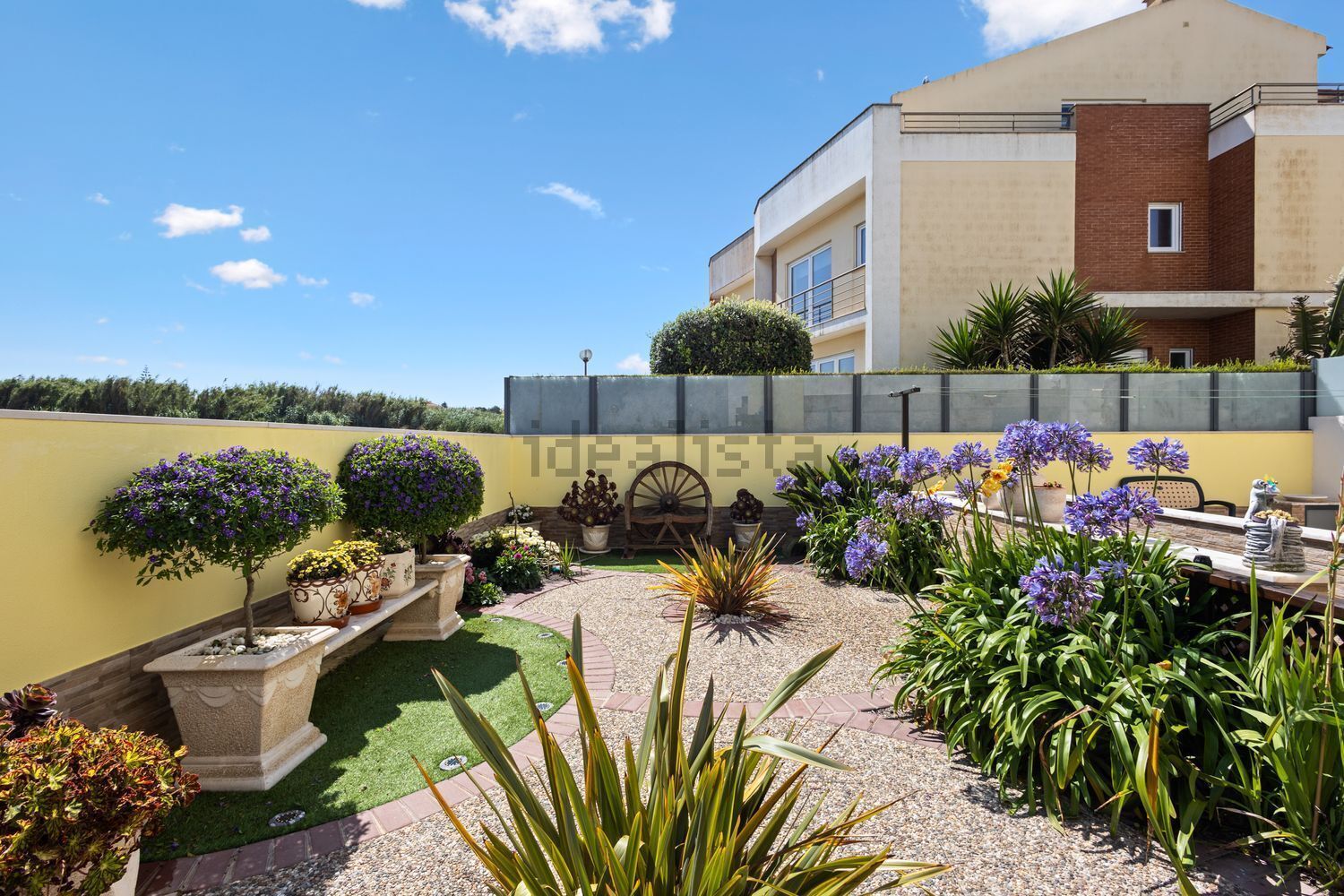 Luxury 3-Bed Villa Garden Elegant garden of a luxury 3-bedroom villa in Santa Cruz with vibrant flowers and lush greenery.