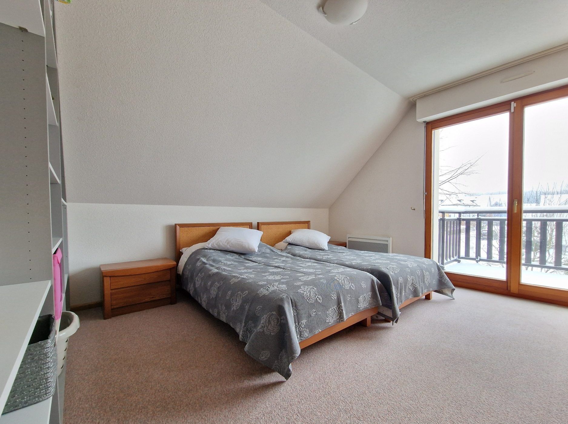 Comfortable bedroom with large balcony overlooking scenic surroundings.