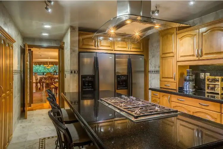 Modern kitchen with black granite countertops and wooden cabinets in a luxury Mexico City apartment.