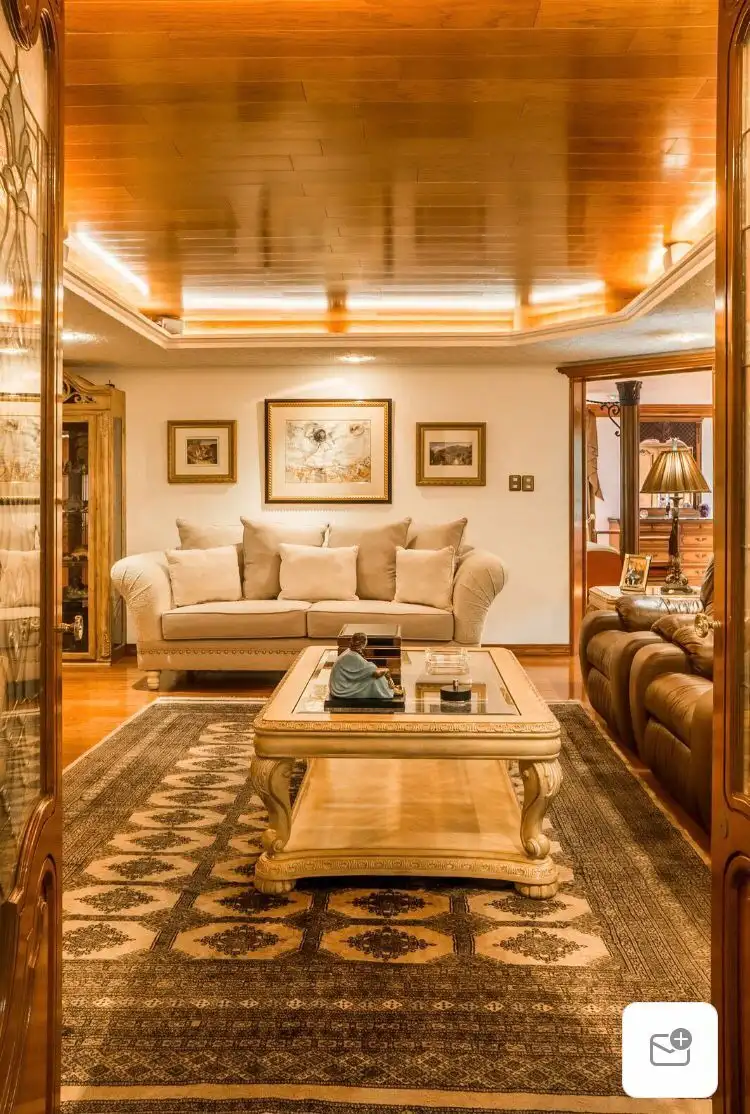 Elegant living room in a luxury Mexico City apartment with stylish furniture and warm wooden accents.