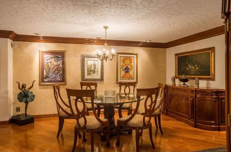 Elegant dining room in a luxury Mexico City apartment with classic wooden furniture and artwork.