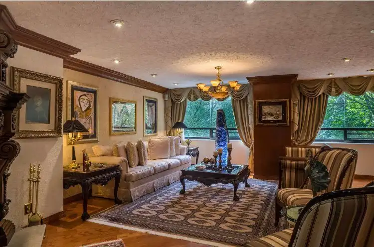 Elegant living room in a luxury Mexico City apartment with classic decor and large windows.