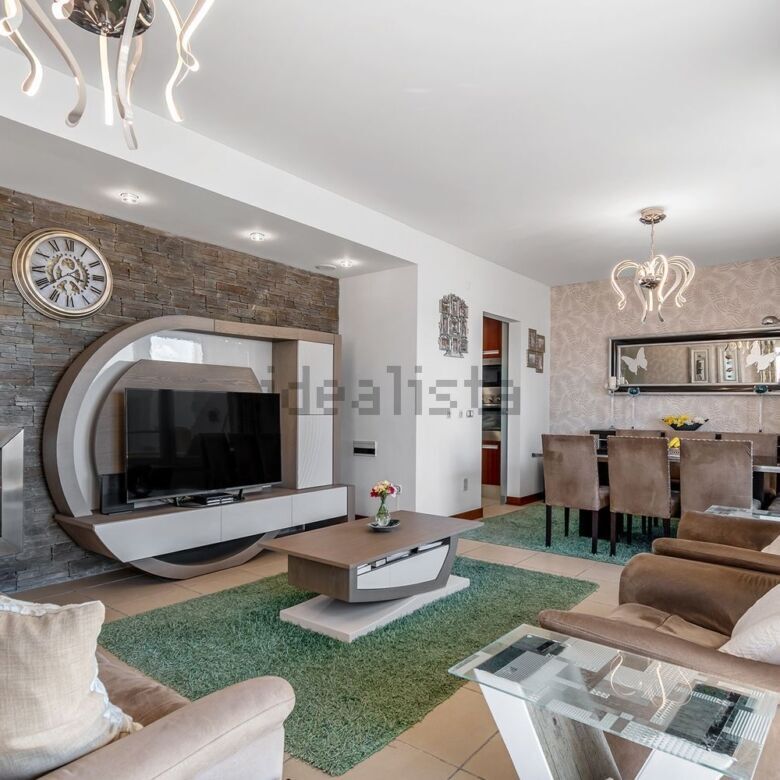 Spacious living room with modern decor, fireplace, and entertainment center in Santa Cruz villa.