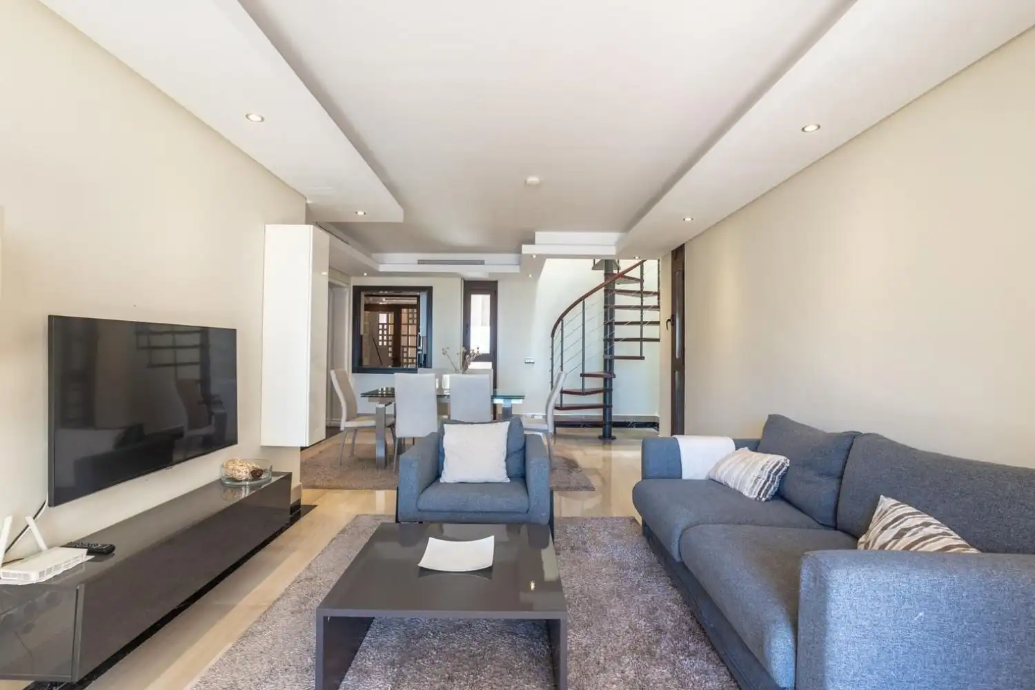 Spacious living room of a new Golden Mile beachfront duplex penthouse with modern decor and sea view.