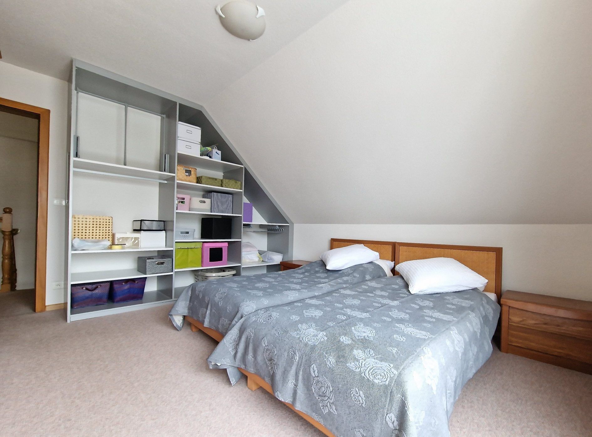 Spacious bedroom with a large bed and built-in shelving unit in Seppois-le-Bas. Ideal for comfortabl.