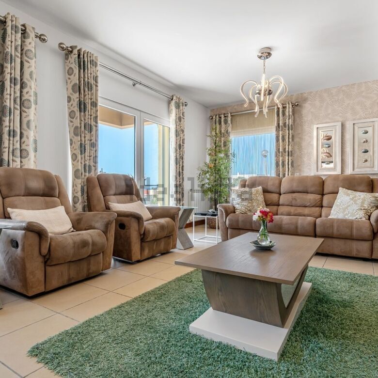 Elegant living room with large windows and comfortable seating.