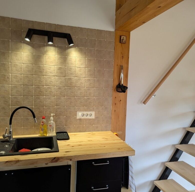 Charming 1-bedroom log cabin kitchen with modern fixtures in Grozăvești, perfect for a peaceful retr.
