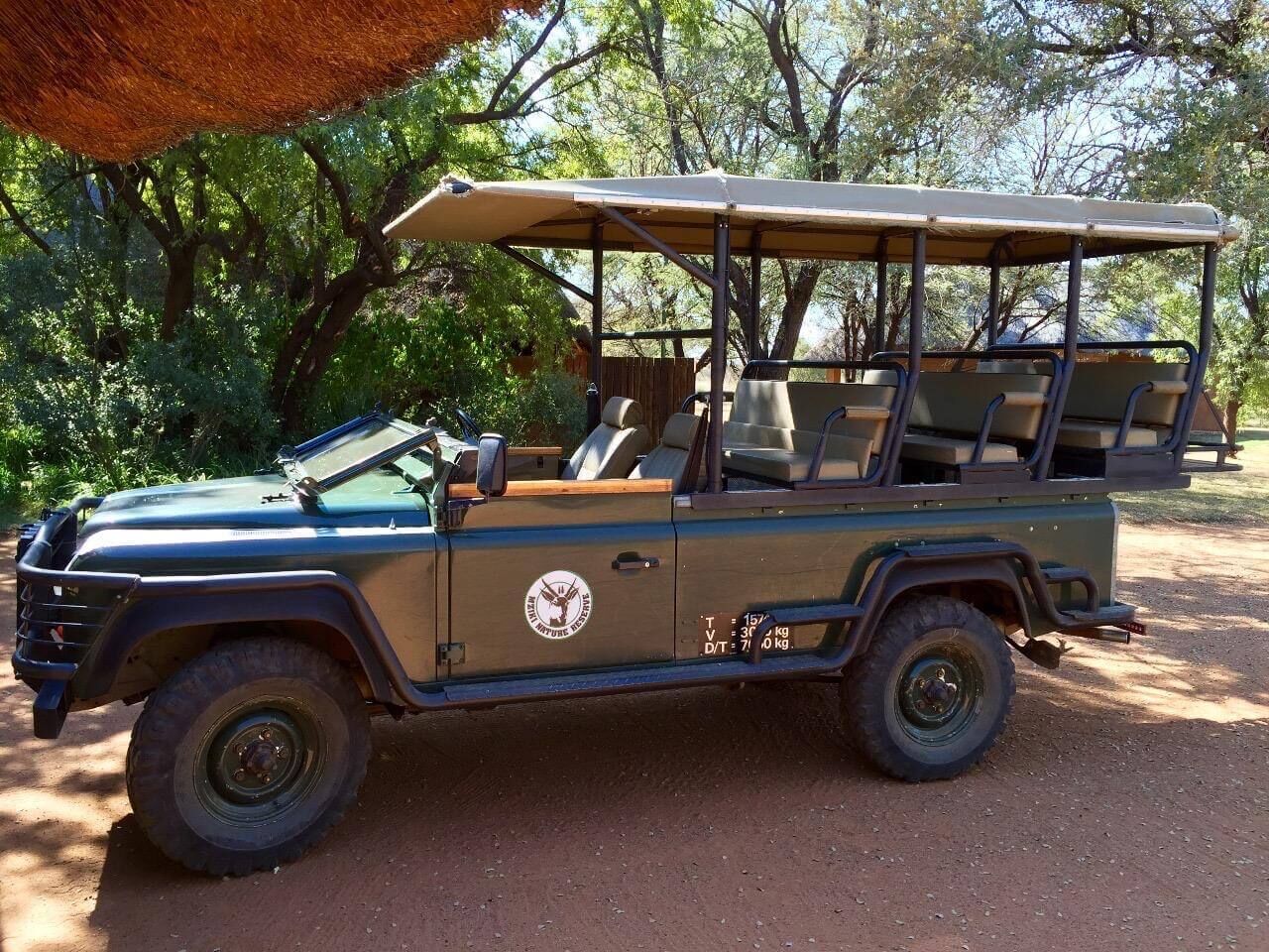Golf cart in a lush, green natural reserve setting.