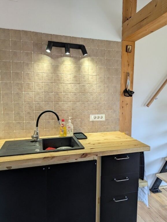 Cozy log cabin kitchen with modern sink and lighting in Grozăvești.