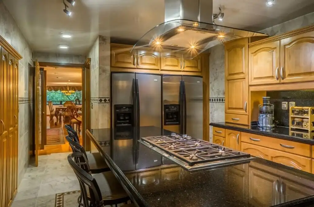 Modern kitchen in luxury Mexico City apartment with wooden cabinets and stainless steel appliances.