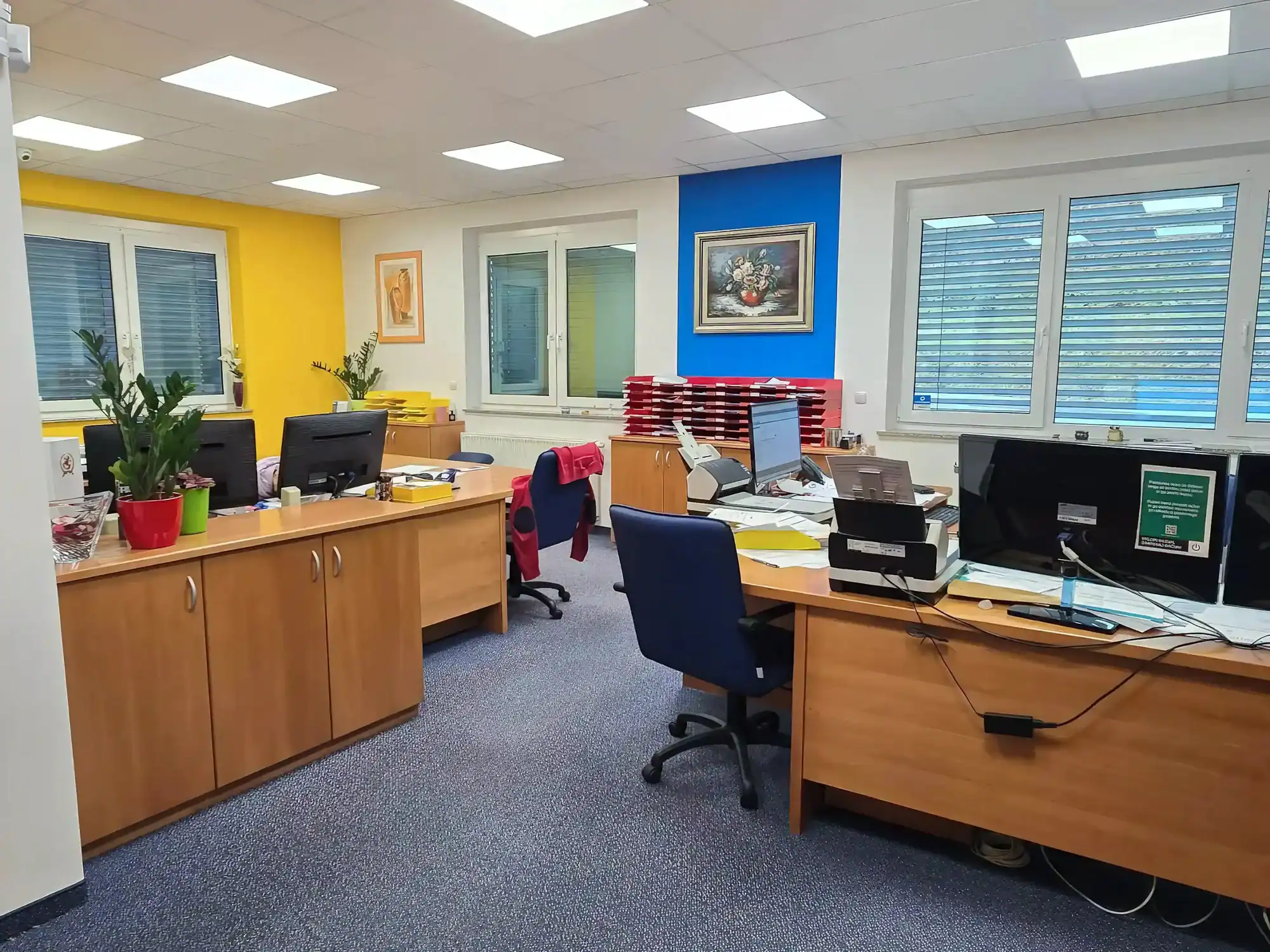 Office space with desks, chairs, and colorful walls for sale in Rogatec.