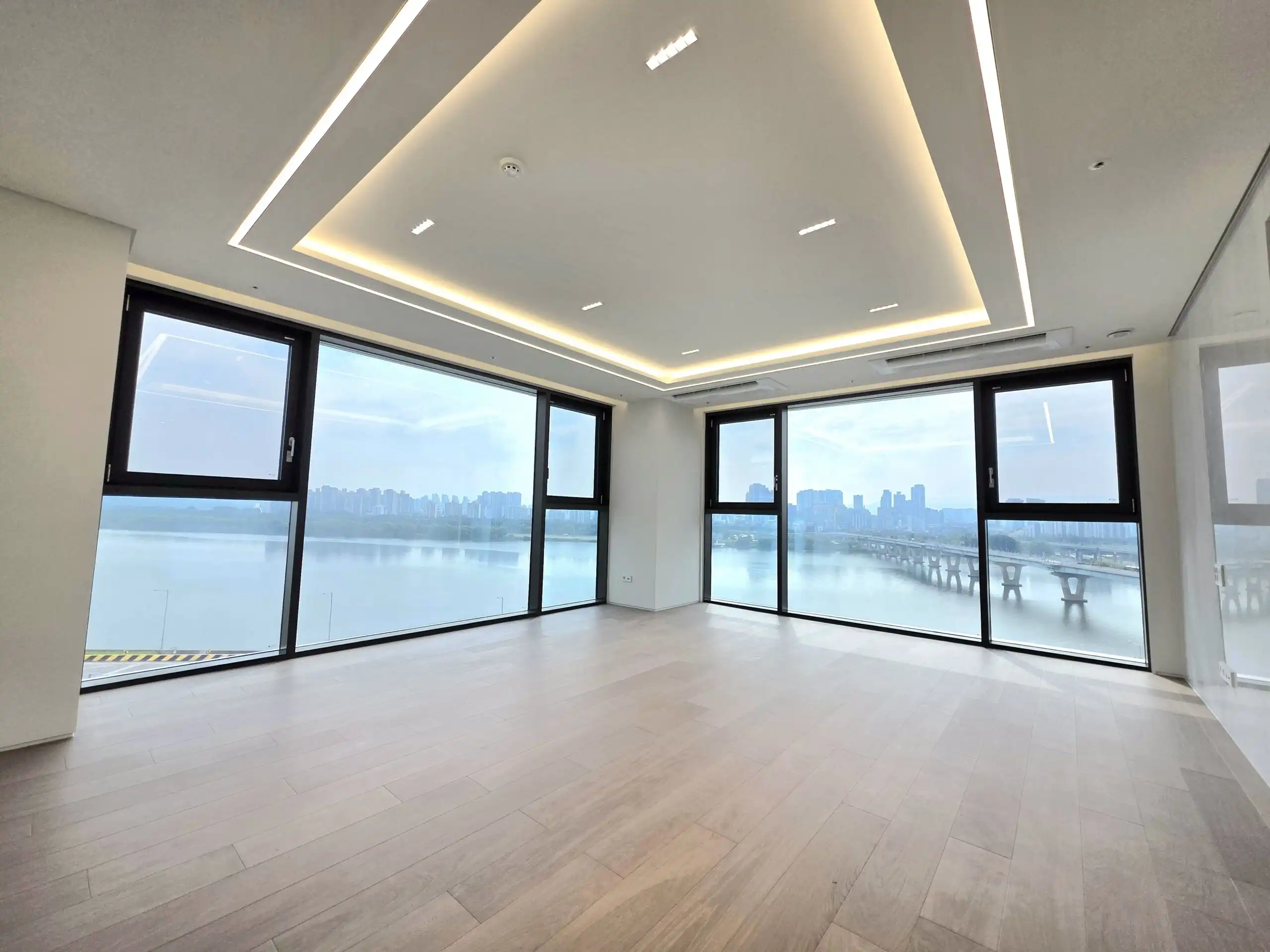 Modern ultra-luxury apartment in Seoul with panoramic river and city skyline views.